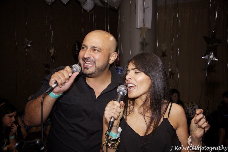 Couple singing karaoke - party photography